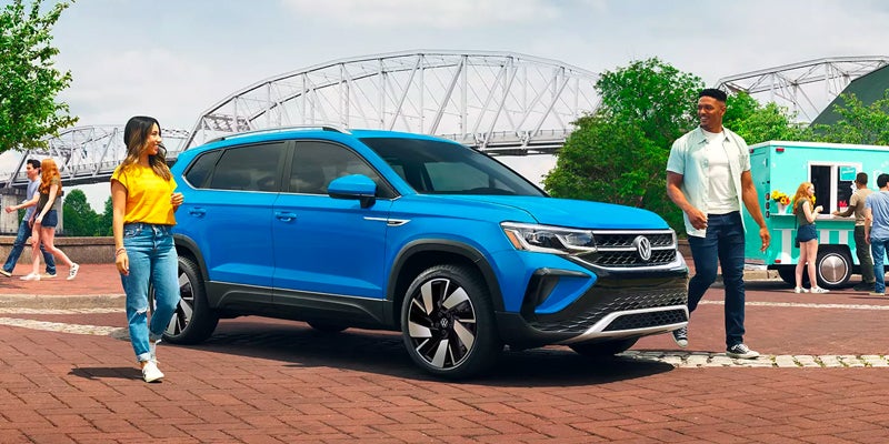 people around Volkswagen Taos in a park