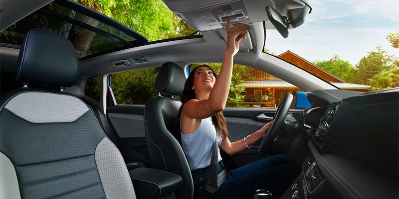 girl opening sunroof of Volkswagen Taos