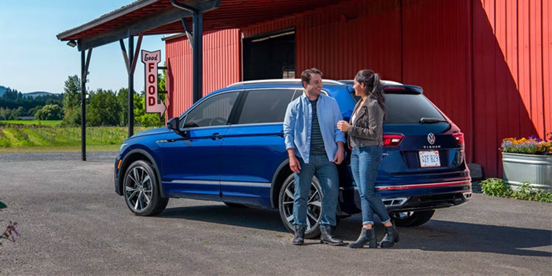 couple standing near Volkswagen Tiguan